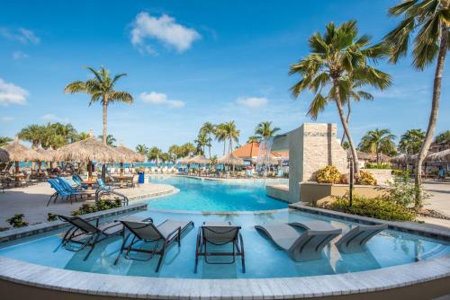 棕榈滩普拉亚琳达海滩度假村 的度假村的游泳池,配有椅子和棕榈树