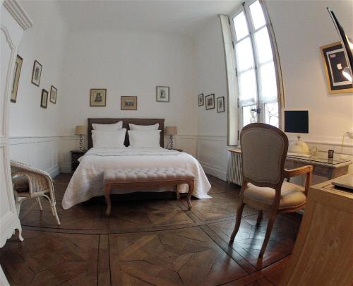 布尔日Maison Colladon的一间卧室配有一张大床和一把椅子