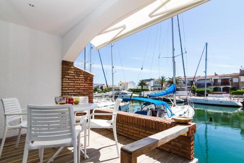 艾姆布里亚布拉瓦Vista Roses Mar - Casa Pescador的一个带桌椅和船只的庭院