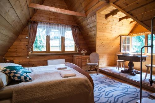维托韦Osada Oleńka Witów的小木屋内的卧室配有一张床和钢琴