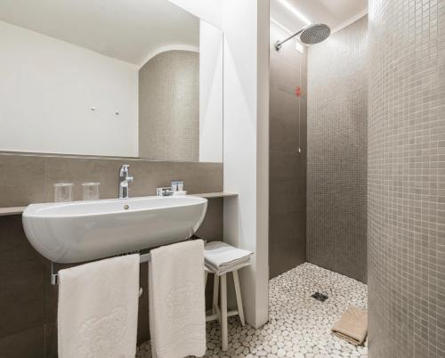 科莫苏西大都会酒店的浴室配有盥洗盆、淋浴和毛巾