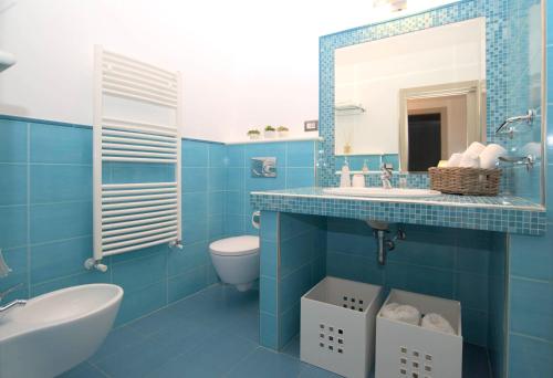 陶尔米纳Taonasi Mazzarò Apartments的蓝色的浴室设有水槽和卫生间