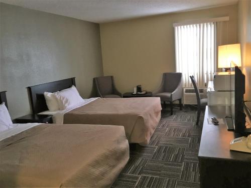 魔鬼湖Sunlac Inn Devils Lake的酒店客房设有两张床和电视。