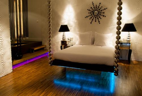 马德里Abalú Small Luxury & Design Boutique Hotel的卧室配有带镜子的秋千床