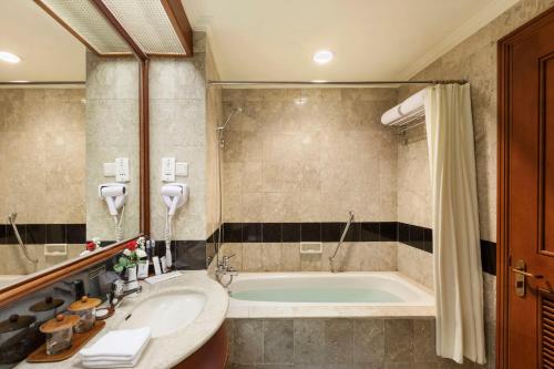 Cikampek普尔瓦卡尔塔尊贵广场酒店的带浴缸和盥洗盆的浴室