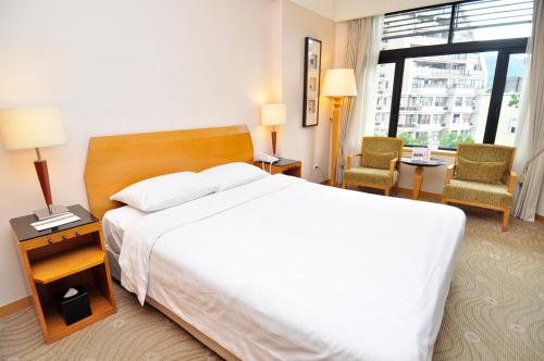 台北北投春天酒店的酒店客房带一张大床和两张椅子