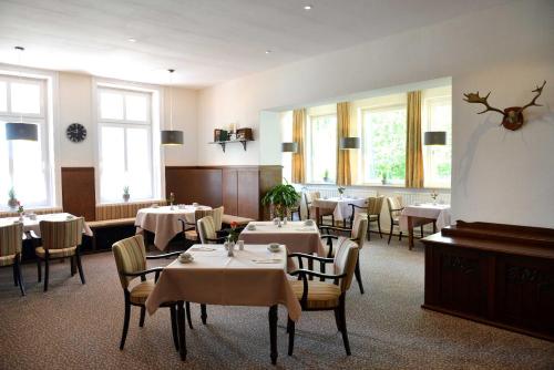 吕贝克阿尼姆斯赫伽尼酒店的用餐室设有桌椅和窗户。