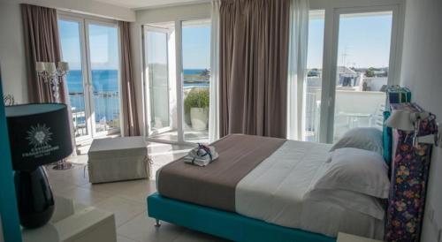 托雷桑塔萨宾娜Hotel Cicò的一间卧室设有一张床,享有海景