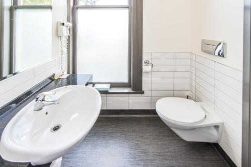 旺格努伊拉特兰阿尔姆旅馆的白色的浴室设有水槽和卫生间。