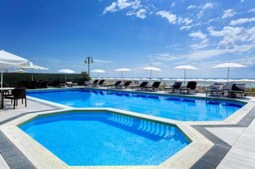 利多迪耶索罗拜伦贝拉维斯特酒店的一个带椅子和遮阳伞的大型游泳池