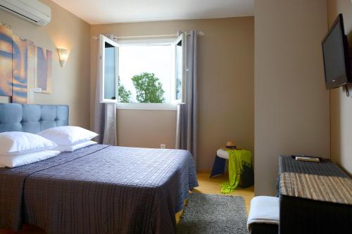 卢恰纳里多酒店的一间卧室设有蓝色的床和窗户。
