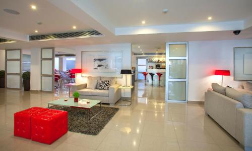 拉纳卡阿莫格斯精品酒店的带沙发和红色凳子的客厅
