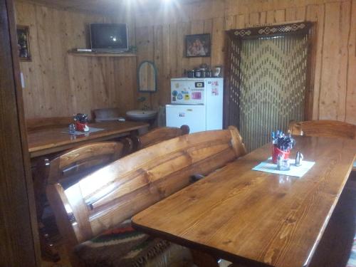 米库利钦Shovkova Kosytsia的一间带木桌和冰箱的用餐室