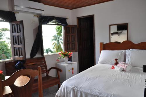 莫罗圣保罗Amendoeira Hotel da Vila的卧室配有白色的床和2扇窗户。