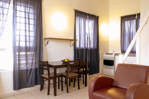 威廉斯塔德橙色伦勃朗公寓式酒店的厨房配有餐桌和椅子