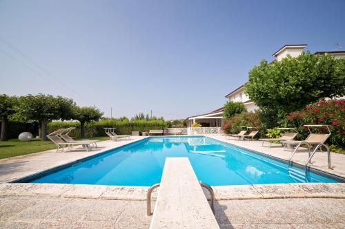 西维尔诺瓦·马尔凯Hotel Country House La Radice的游泳池周围设有躺椅和椅子
