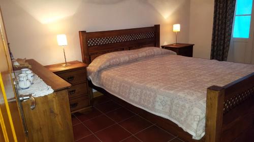 富尔纳斯Casa da Beija - House Azores的一间卧室配有一张床和两个带灯的床头柜