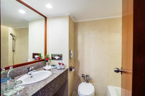 曼谷曼谷皇宫酒店的一间带水槽、卫生间和镜子的浴室
