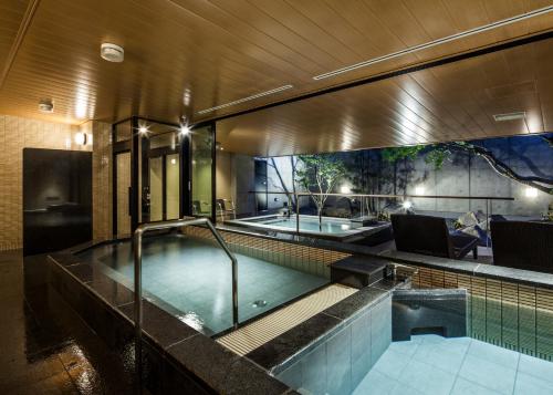福井福井曼藤伊可玛酒店的一座大楼内带热水浴池的游泳池