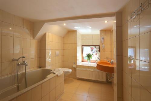 博兹达尔绿屋酒店的带浴缸、卫生间和盥洗盆的浴室