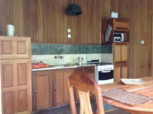 TrindadeCasa Ediana的厨房配有木制橱柜、桌子和炉灶。