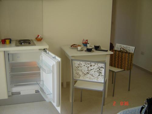 托雷拉皮罗Il Sole Il Mare Il Vento的一间带桌子和冰箱的小厨房