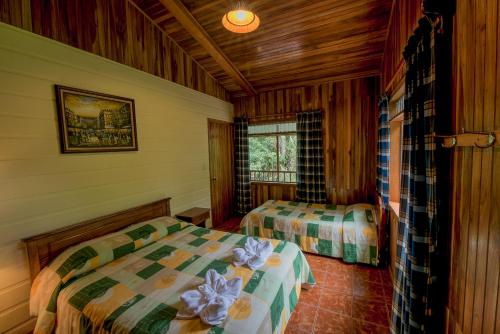蒙泰韦尔德哥斯达黎加Hospedaje Mariposa的一间卧室设有两张床和窗户。