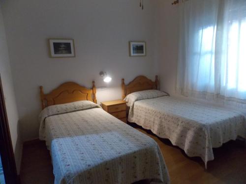 圣玛丽亚港Pensión La Palma的一间卧室设有两张床和窗户。