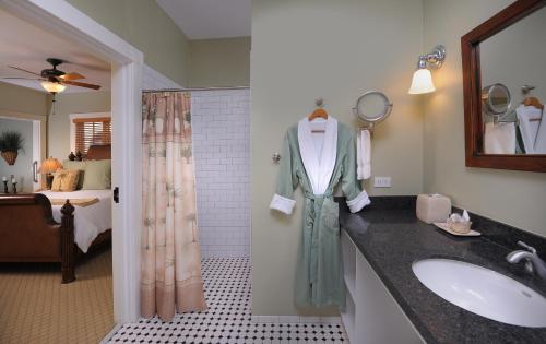 圣地亚哥1906 Lodge的一间带水槽和淋浴的浴室以及一张床