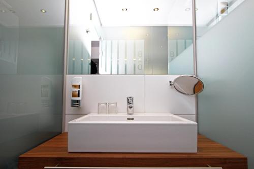 维也纳艾姆克尔公园酒店的浴室设有白色水槽和镜子