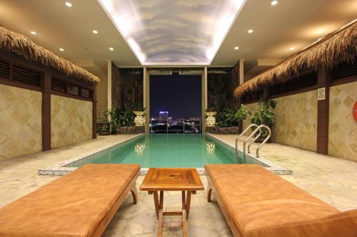 名古屋哈默尼套房酒店的一座带两个长椅的游泳池
