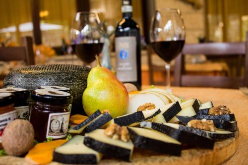 蒙特普齐亚诺Hotel Ristorante Tre Stelle的一张桌子,上面放着一盘食物和一杯葡萄酒