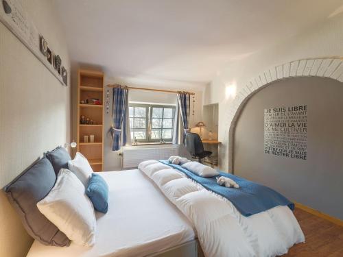 博兰Clos Du Ry De Snaye的一间卧室配有一张带蓝白色枕头的大床
