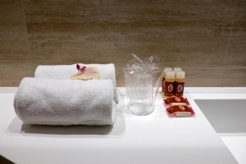 巴塞罗那驰酒店的浴室柜台提供毛巾和蜂蜜瓶