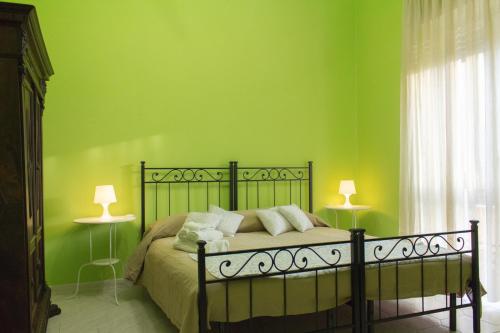 罗马迪帕帕公寓的一间卧室配有一张带绿色墙壁的床和两盏灯。