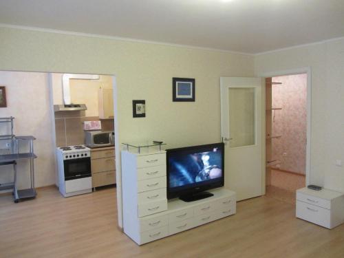 乌法Apartment Revolutsionnaya 72的一间客厅,客厅内配有白色梳妆台上的电视