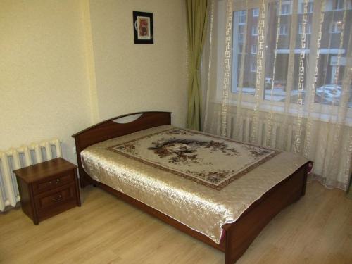 乌法Apartment Revolutsionnaya 72的窗户客房内的小床