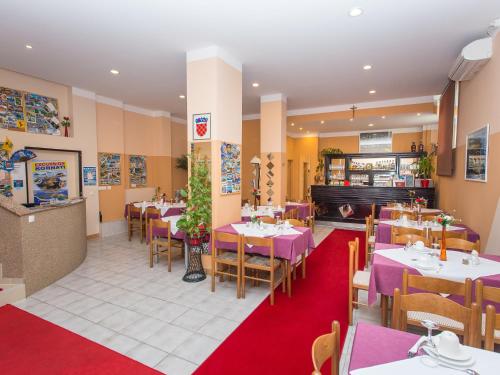 扎达尔瓦伦缇纳别墅酒店的餐厅配有桌椅和紫色桌子