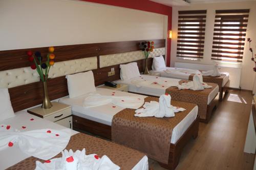 科尼亚麦斯奈维酒店的一间设有三张鲜花的床的房间
