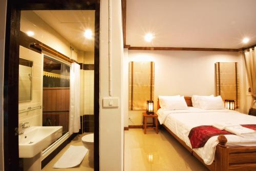 安帕瓦班南潘度假村的一间卧室配有一张床、一个浴缸和一个水槽