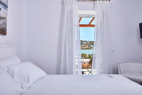 奥诺斯米科诺斯波浪海滨公寓式酒店的一间卧室配有一张床,享有海景