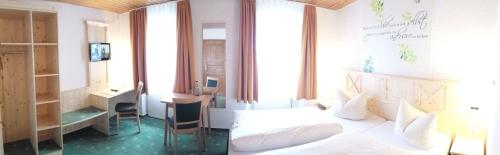 奥伯德尔丁根祖尔奥尔穆勒宾馆的一间卧室配有一张床、一张书桌和一个窗户。