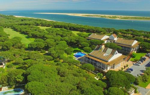 厄尔-汝姆披多努弗波提尔高尔夫酒店的享有树木和大海的房屋的空中景致
