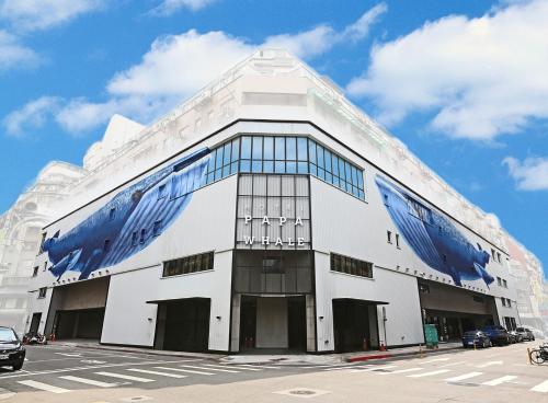 台北Hotel PaPa Whale的白色的大建筑,街道上设有蓝色窗户