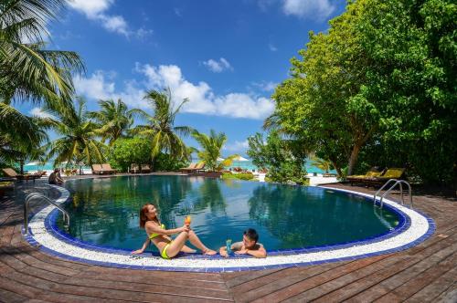 南马累环礁Adaaran Prestige Vadoo - Adults Only Premium All Inclusive with Free Transfers的两个女孩坐在度假村的游泳池里