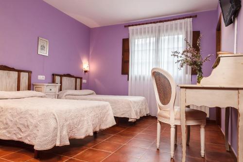 纳维亚苏琴乡村酒店的酒店客房带两张床和一张桌子以及椅子。