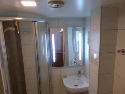 蒙费列叙尔莱Hotel & Restaurant Heliotel的浴室配有盥洗盆和带镜子的淋浴