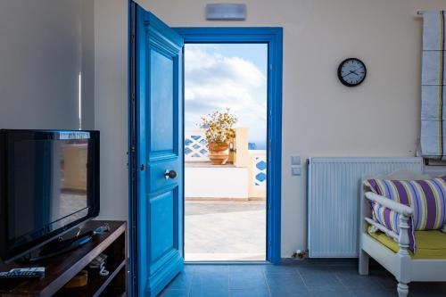 Olympos奥林波斯列岛公寓的一间设有蓝色门和电视的房间