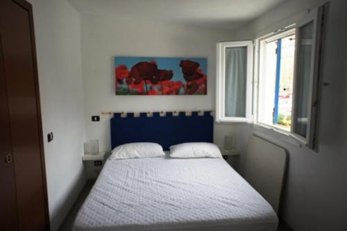 波蒙特阿苏拉度假屋的一间卧室配有一张带蓝色床头板的床和窗户
