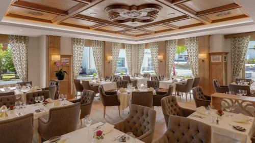 博纳杜斯Hotel Alte Post Bonaduz的餐厅设有白色的桌椅和窗户。